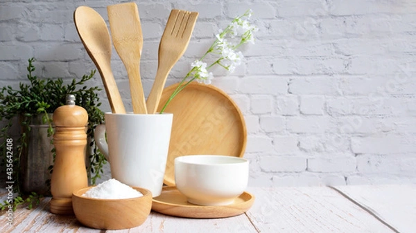 Fototapeta Kitchen accessories in white wooden table and white background and white tableware with salt in wooden bowl and tree. Kitchen minimal cooking time in holiday concept.