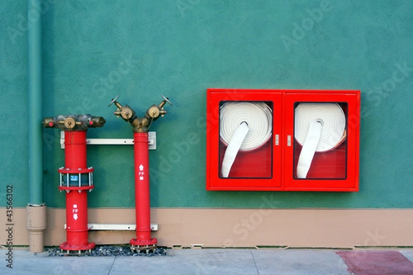 Fototapeta Hydrant with water hoses and fire extinguish equipment