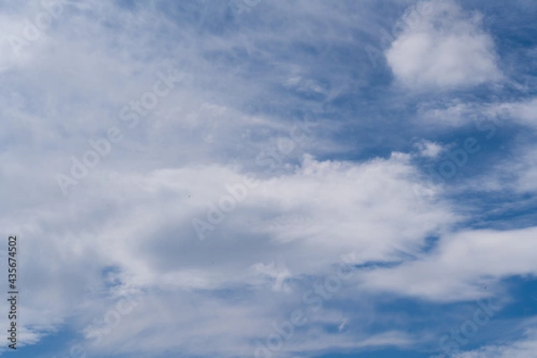 Fototapeta Blue sky with light thin white clouds in bright sunlight 