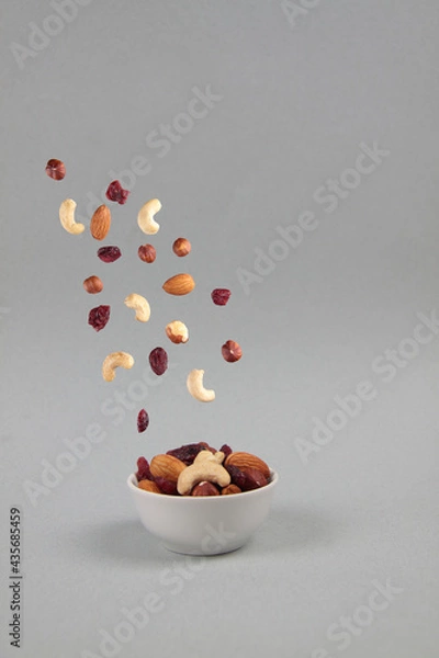 Obraz fruit mix pouring into a bowl isolated on gray background - flying food concept