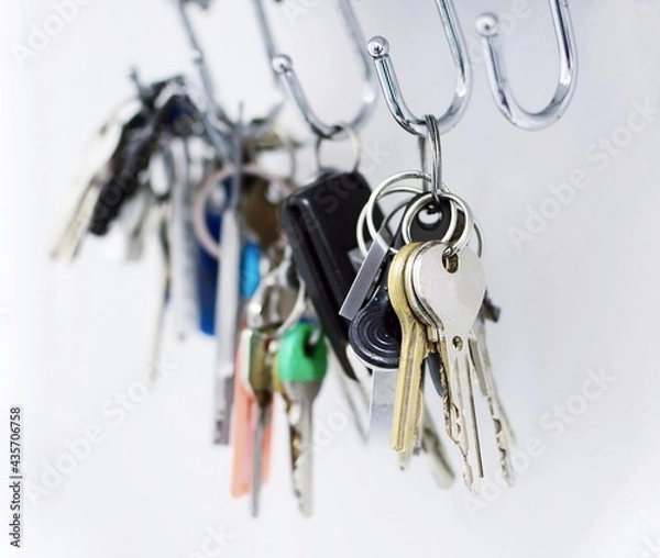 Fototapeta Close up of a bunch of keys hanging on the hooks.