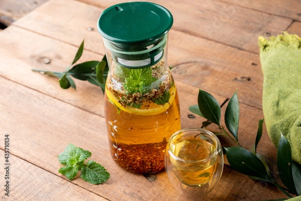 Fototapeta Preparation of tea with mint leaves and infuser