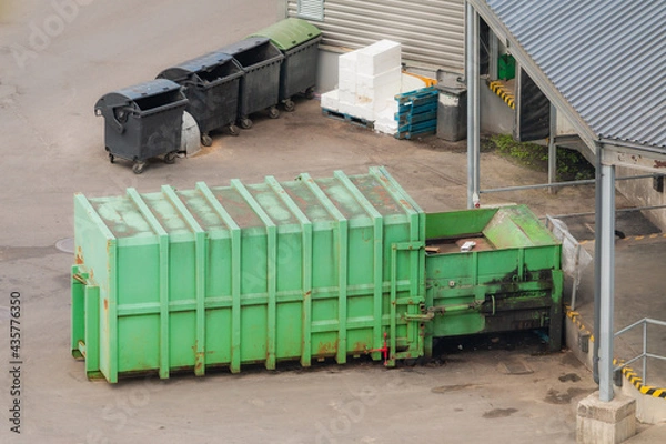 Fototapeta Green paper squeezer container and garabage press machine recycle cardboard to reusable materia