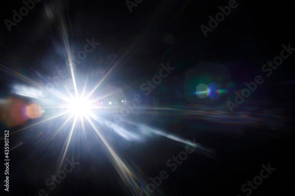 Fototapeta Easy to add lens flare effects for overlay designs or screen blending mode to make high-quality images. Abstract sun burst, digital flare, iridescent glare over black background.