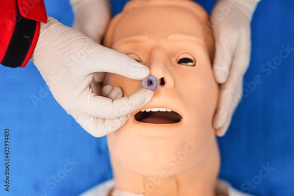 Fototapeta Top view of medical manipulation for airway management. Nasopharyngeal tube airway insertion by stuff in a black gloves on a simulation mannequin dummy during medical training. ACLS