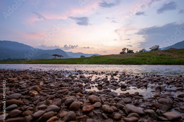 Fototapeta Wide view, low angle view, riverside scenery, mountains, evening sky, falling summer river, see small boulders