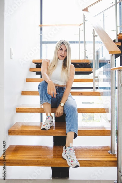 Obraz Vertical shot of a Hispanic female sitting on wooden stairs
