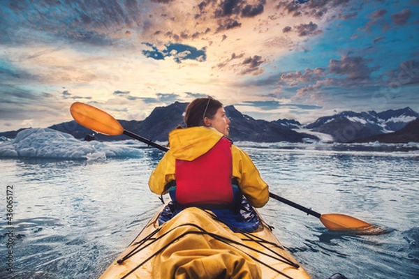 Fototapeta Woman paddle a canoe on an icy bay in Alaska exploring glaciers