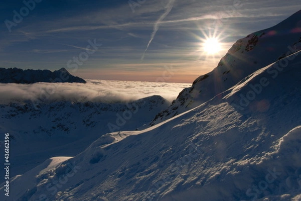 Obraz The setting sun in the mountains. Sunset in the mountains. Clouds in a mountain valley.