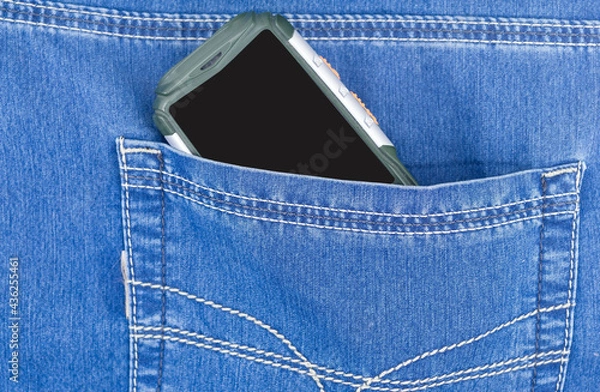 Fototapeta Cellular telephone in blue jeans pocket