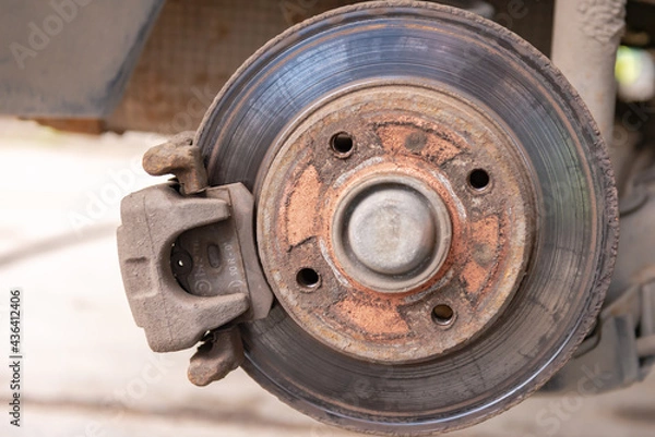 Obraz Old car brake disc. The brakes on the car require regular maintenance. Very close-up of the brake disc and pads when replacing the wheel.