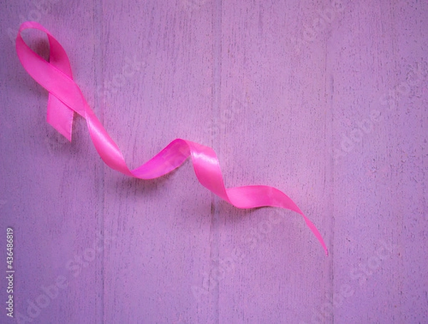 Obraz Pink breast cancer ribbon on white wooden table.
