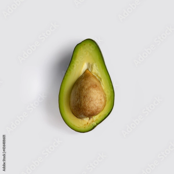 Obraz Half a green ripe avocado fruit with stone inside. Isolated on light-gray background