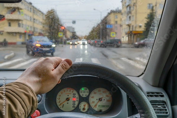 Fototapeta driver hand on the steering wheel inside the car while parking at a traffic light in front of a pedestrian crossing