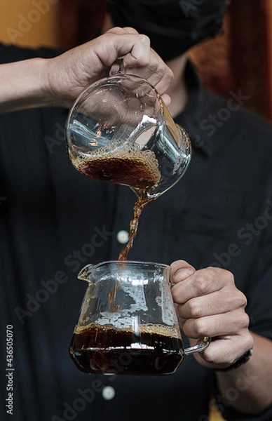 Fototapeta The drip coffee flows into another jug.