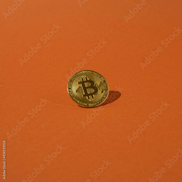 Fototapeta Gold bitcoin is placed on an orange background.