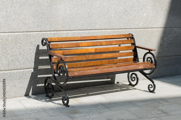 Obraz Empty wooden bench among concrete in the sunny day. Light and shadow