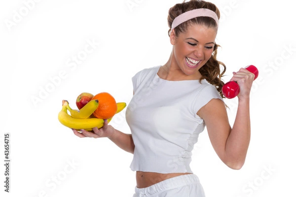 Fototapeta Lachende junge Frau mit Früchten und einer roten Hantel trainie