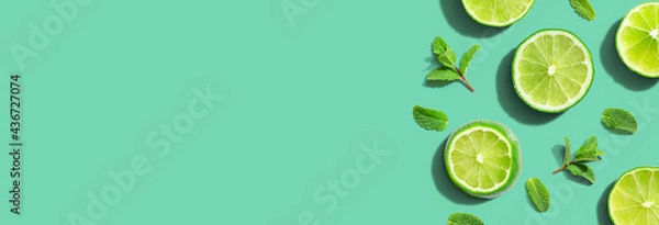 Obraz Fresh green limes with mints overhead view