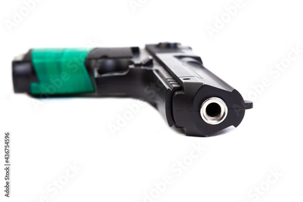 Fototapeta A large black pistol with a handle wrapped in green electrical tape lies on a white isolated background
