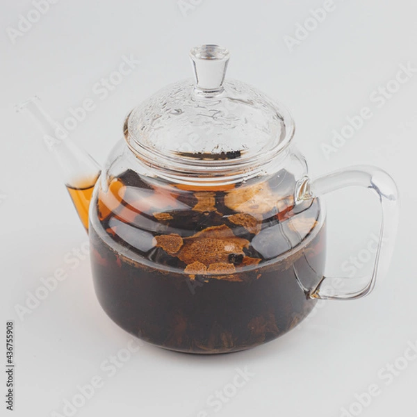 Fototapeta glass teapot filled with pu-erh tea in tangerine
