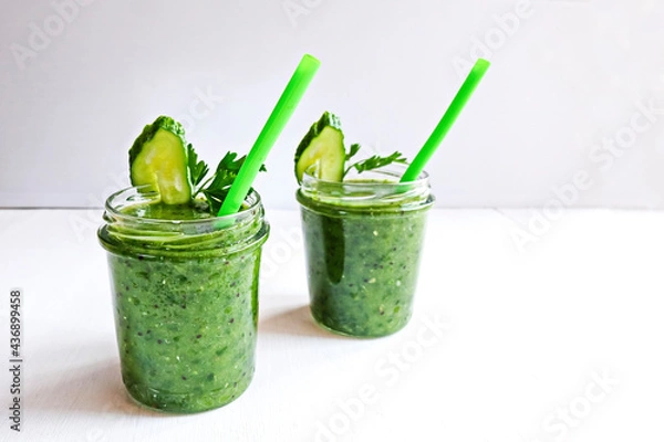 Fototapeta Green cocktail of spinach, lemon, cucumber and parsley on a light background. The concept of healthy nutrition, detox, green, diet, vegan, keto, fit