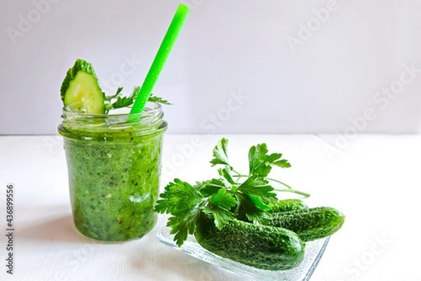 Fototapeta Green cocktail of spinach, lemon, cucumber and parsley on a light background. The concept of healthy nutrition, detox, green, diet, vegan, keto, fit