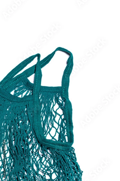 Obraz The green string bag was shot in macro style on a white background. There is a space for text. Vertical photo, flat lay style for your eco-friendly design.
