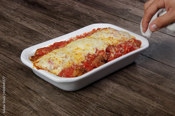 Obraz Steak Parmegiana or Parmegian Filet, made with breaded steak, tomato sauce, mozzarella cheese and Parmesan cheese. Hand beside holding napkin.
