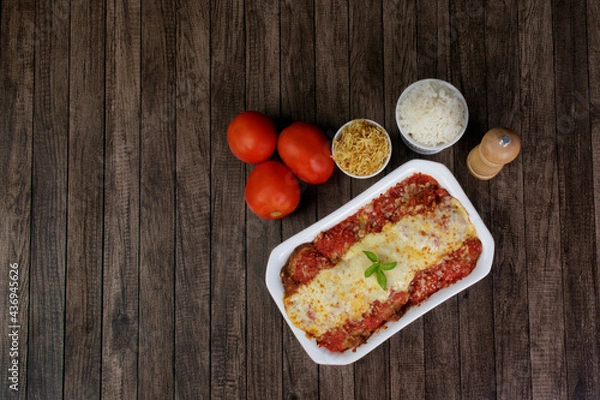 Fototapeta Steak Parmegiana or Parmegian Filet, made with breaded steak, red tomato sauce, mozzarella and parmesan cheese. White Rice and Potato Straw. Top view photo with free space for texts.