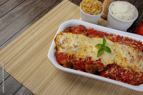 Obraz Steak Parmegiana or Parmegian Filet, made with breaded beef, red tomato sauce, mozzarella cheese and gratin Parmesan. White rice and potato straw. Free space for text.