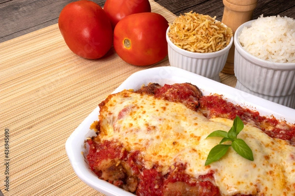 Fototapeta Steak Parmegiana or Parmegian Filet, made with breaded steak, tomato sauce, mozzarella cheese and parmesan au gratin. White rice and potato straw. Close-up photo of Brazilian cuisine.