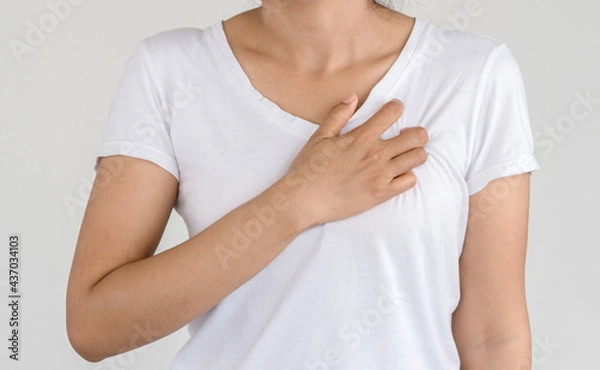 Fototapeta Young female suffering from severe chest pain. Warning signs of unstable angina or myocardial infarction disease. Health care and cardiological concept.