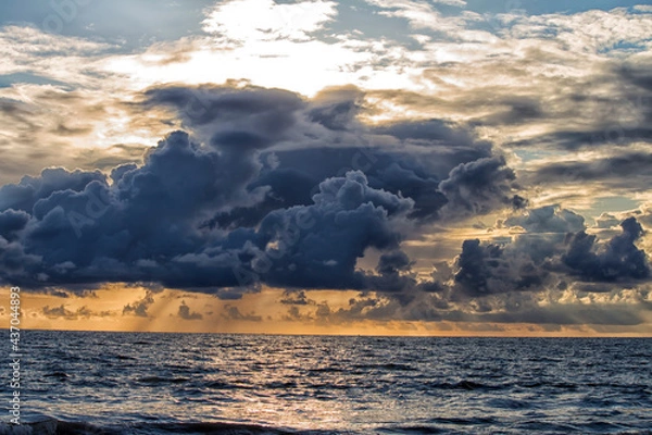 Fototapeta Pre-monsoon clouds during evening over a beach
