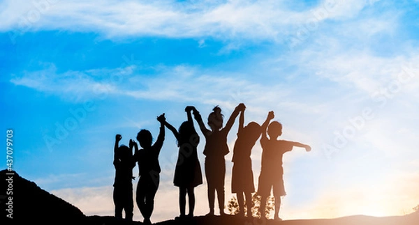 Obraz Silhouette back view refugee kid group playing in sunset.Kid child boy and girl worship.Raised hands blessing praying worship, Hope, freedom, Diverse, Faith, Praise, world refugee day.Adoption kid.