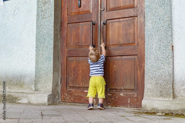 Fototapeta child pulling on the door