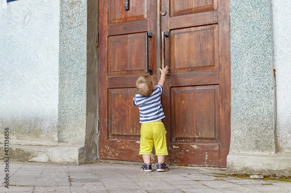 Fototapeta child pulling on the door