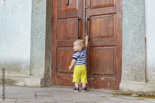 Fototapeta child pulling on the door