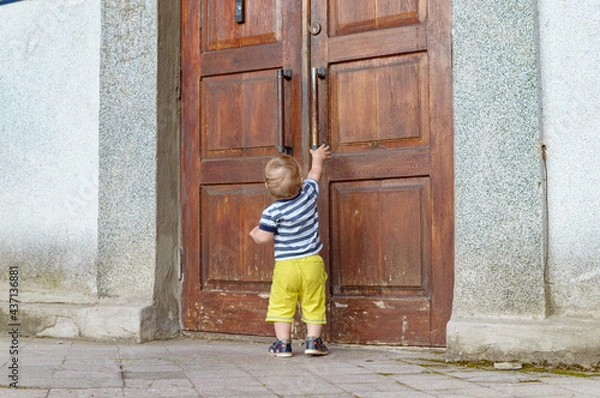 Fototapeta child pulling on the door