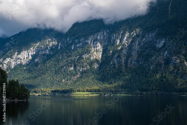 Fototapeta Panoramic view overlooking the beautiful lake of Hallstatter see with tiny houses and a landscape of mountains in the background.