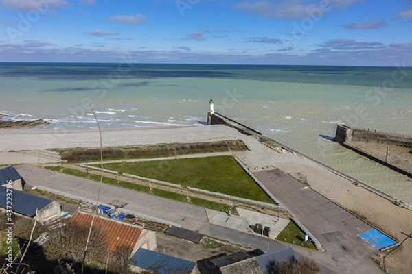 Fototapeta Seawall and pebble beach, lighthouse at entrance to Saint-Valery-en-Caux harbor. Saint-Valery-en-Caux - small coastal resort of the Pays de Caux. Saint-Valery-en-Caux, Upper Normandy, France.