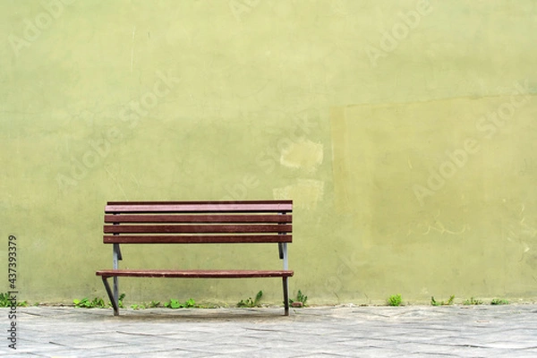 Fototapeta Wooden bench on the background of the building facade. Copy space