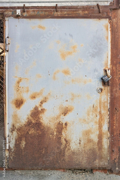 Fototapeta Grungy rusty textured metal door with padlock