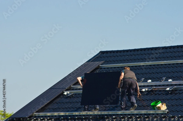 Obraz Installing modern black solar panels on the roof