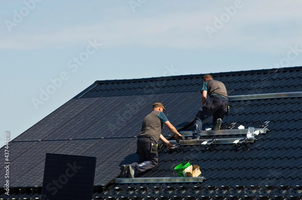 Obraz Installing modern black solar panels on the roof
