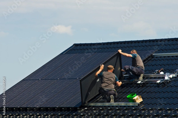 Obraz Installing modern black solar panels on the roof