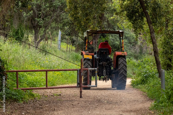 Obraz Tracktor on a trail with a gate.