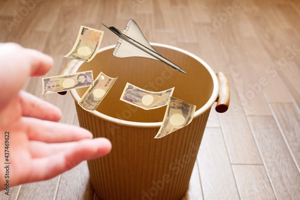Fototapeta 高コストの超音速旅客機を手放すイメージでお金と共にゴミ箱に投げ捨てる
