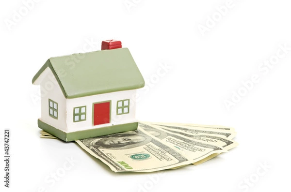 Fototapeta Model of a house lying on some banknotes