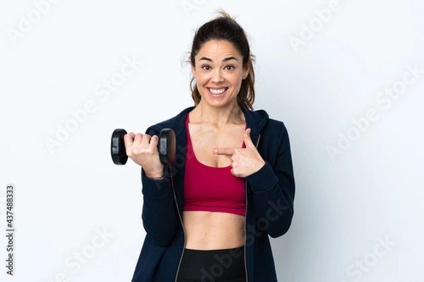 Fototapeta Sport woman making weightlifting over isolated white background with surprise facial expression